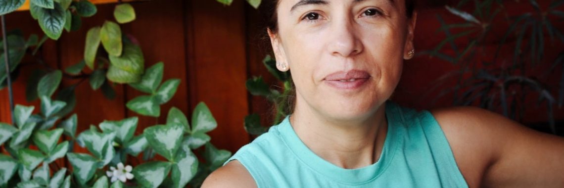 Woman in a teal tank top with plants